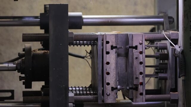 Detailed industrial shot of an automated sand casting molding press machine fully closed