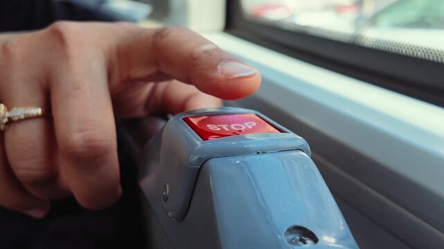 Bus stop button in use by passenger on public transport