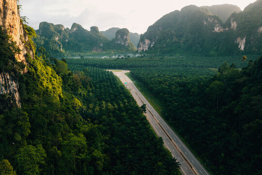 Aerial View of Highway Intersection in Vast Green Valley and Limestone Mountains