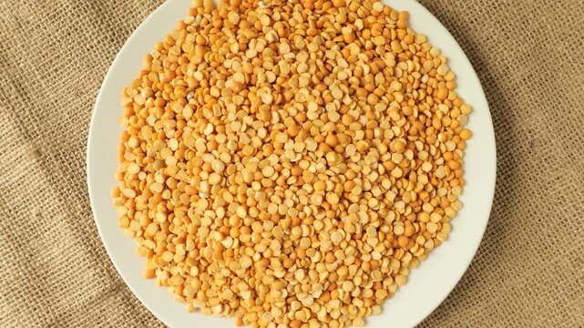 Rotating white plate of yellow split peas