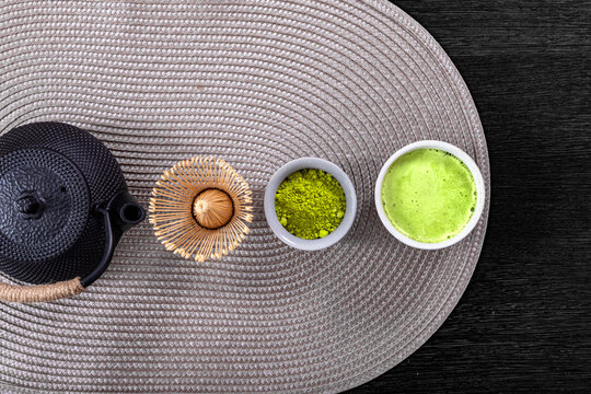 Matcha tea ceremony set with iron teapot, bamboo whisk, green powder and bowl with hot drink. Traditional Japanese organic beverage for wellness, relaxation, mindfulness and health