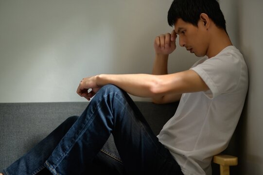 Thoughtful Young Man Sitting Alone in Quiet Indoor Space
