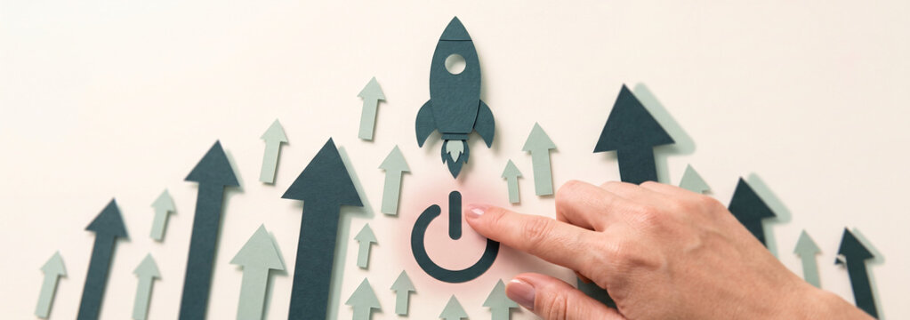 Hand pressing power button to launch rocket. Business startup concept with rising growth arrows.