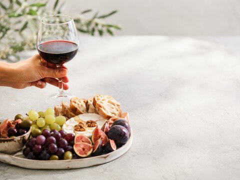 Momento de disfrutar vino tinto con aperitivos en una mesa de m&aacute;rmol