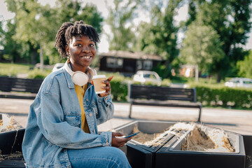 Fototapeta premium Happy young woman drinking coffee outdoors