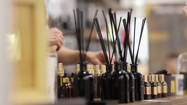 incense sticks in a bottle, closeup. Air flavors, fragrance oils in glass bottles with wooden sticks.
