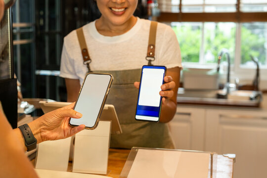 Close up of a customer using a smartphone to make a contactless mobile payment.