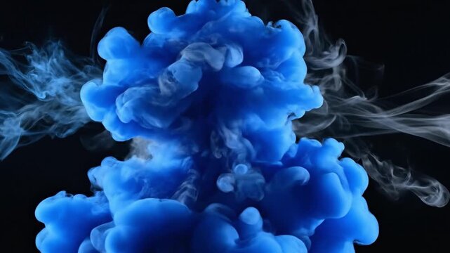 Blue and white ink plumes mixing in water against a dark backdrop creating abstract patterns
