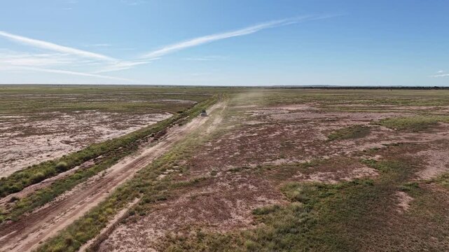 Aerial  flyover of 4WD Prado cruising on dirt road outback NSW Australia