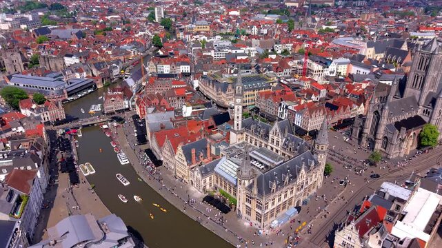 Aerial wide angle panoramic view over Ghent historic old post office building clock tower river canal with tour boats and Saint Nicholas Church under a summer sky