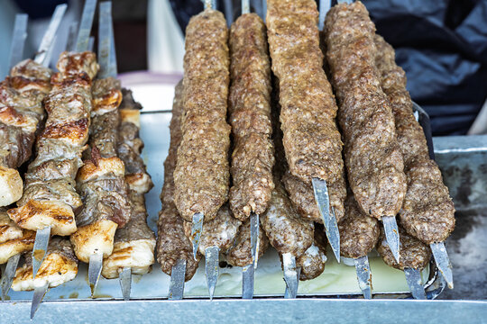 Traditional grilled kebab made from seasoned minced meat and beef skewers with tail fat displayed at a local market. Authentic charcoal barbecue and regional cuisine.