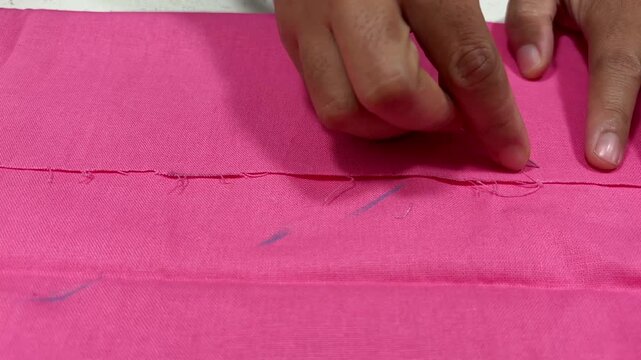 Close up of a dressmaker hand pinning fabric with straight pins for garment pattern preparation