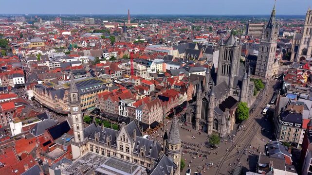 Aerial wide angle panoramic view of Saint Nicholas Church historic town squares with pedestrians the old post office clock tower and red tiled city roofs under a bright summer sky