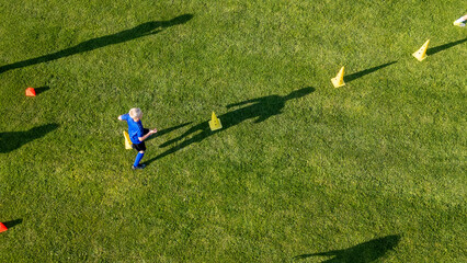 Obraz premium Areal view of football player running agility drills during soccer practice.