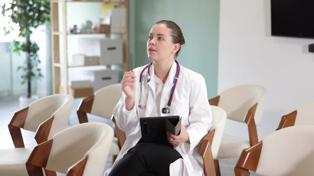  In study room, female medical visitor listens to lecture, makes notes on tablet, conducts self-monitoring and questionnaires after lecture and fills out online form, fills out questionnaire.