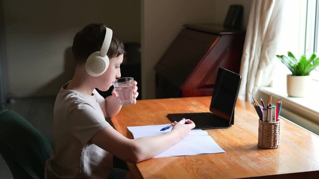 Boy drinking water while taking break from homework