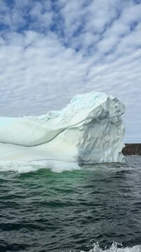Majestic iceberg floats on a dark ocean surface in Newfoundland