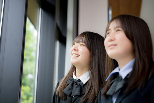 窓の外を見つめる日本人女子高校生複数 将来・進路・希望などの青春や学校イメージのクローズアップ