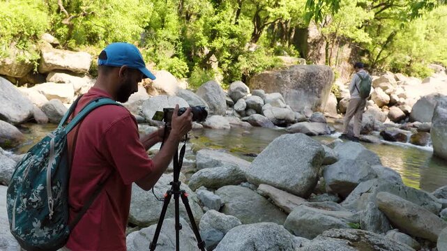 Photographer filming nature at Kareri Lake, Dharamshala, Himachal Pradesh. Travel videography scene.