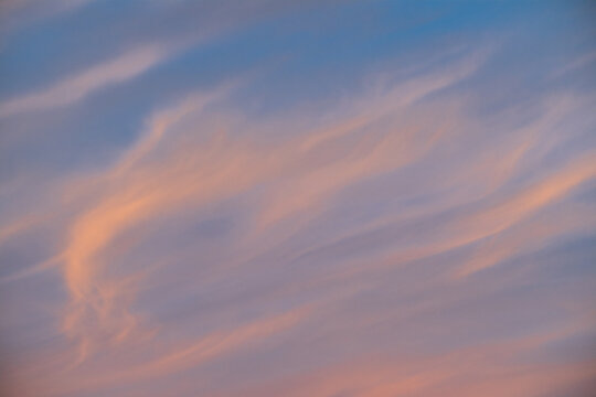 Blue sky in Dawn's First Light and clouds in warm colours