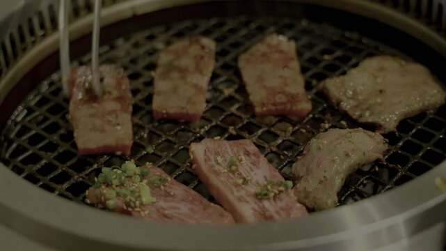 厚切り和牛カルビを焼肉屋で焼きトングで裏返しのシーン
