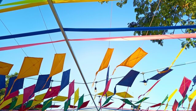 Colorful traditional kites hanging as outdoor festival decoration against blue sky