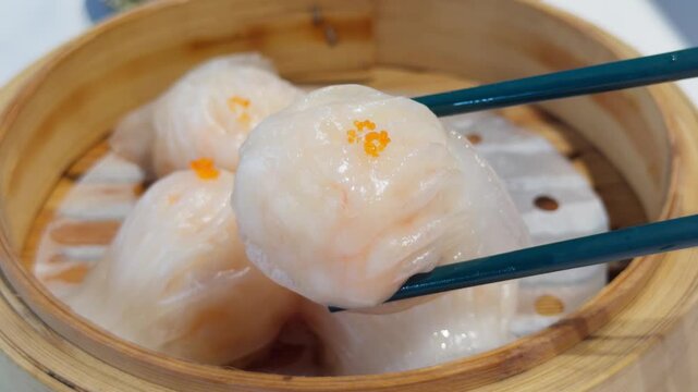 Cantonese Har Gow Shrimp Dumpling Lifted by Chopsticks in Bamboo Steamer