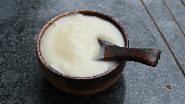 pure desi ghee in wooden bowl on black background