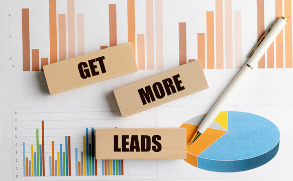 Get more leads message on wooden blocks with business charts and pen representing lead generation marketing growth