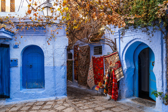 Blue alley with hanging carpets in Chefchaouen Morocco