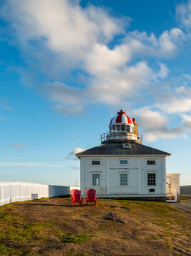 Cape Spear lighthouse at sunset with red chairs