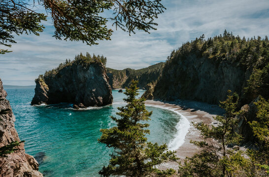Rocky coastline with a secluded turquoise cove in Newfoundland.