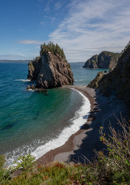 Scenic coastal cove with a large sea stack on sunny day