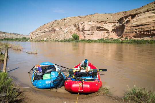 Rafter packing gear in a raft on a desert riverbank
