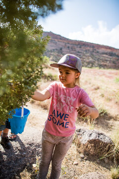 Young girl wearing a hat foraging outdoors
