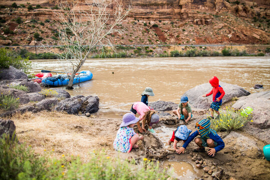 Kids having fun playing in mud on the riverbank