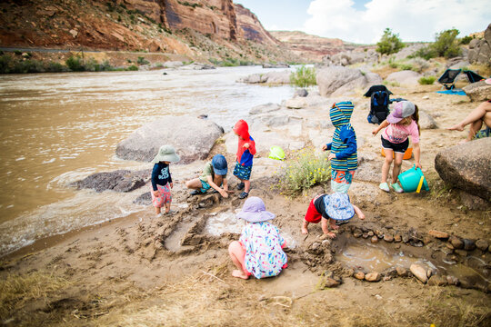 A group of children playing in mud by a river
