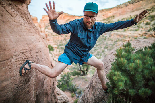 Outdoorsman in mid air leaping between two rocks