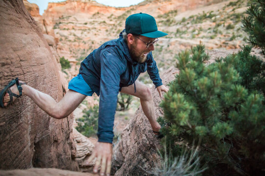 Man carefully navigates a tight rock passage