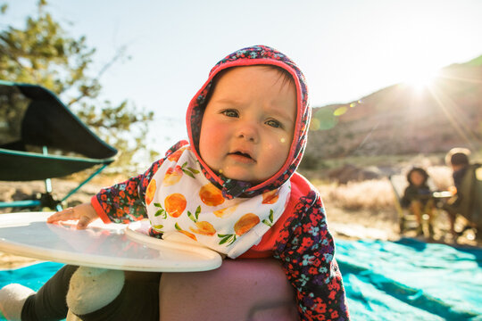 Cute baby in a hoodie at a sunny campsite