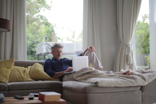 Mature man relaxing at home with laptop computer