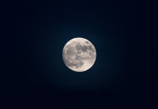 Majestic full moon glowing brightly in the midnight sky