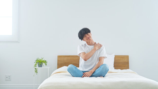 ベッドでリラックスする男性。ライフスタイル、くつろぐ、寝室、ストレッチ、健康、ヘルスケア、目覚め