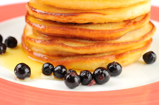 Stack of Pancakes with Blueberries and Syrup on Plate