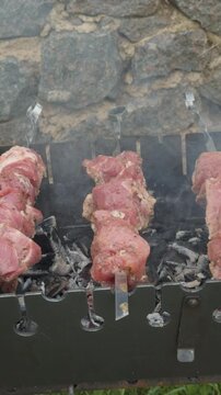 Marinated raw pork skewers cooking on a barbecue grill