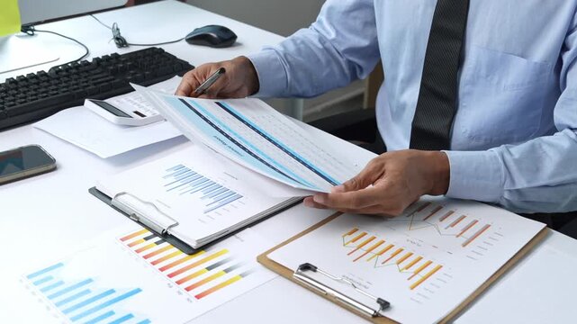 Businessman analyzing financial reports and calculating data