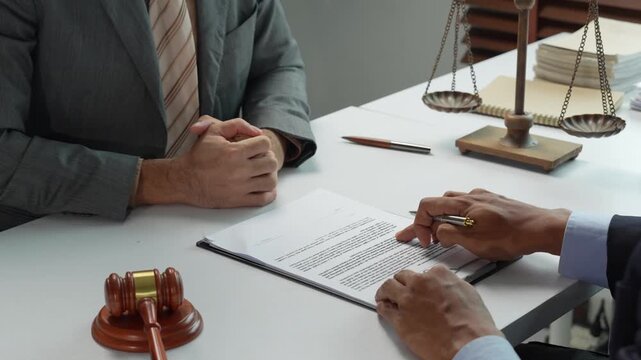 Client signing a legal document in a lawyer's office