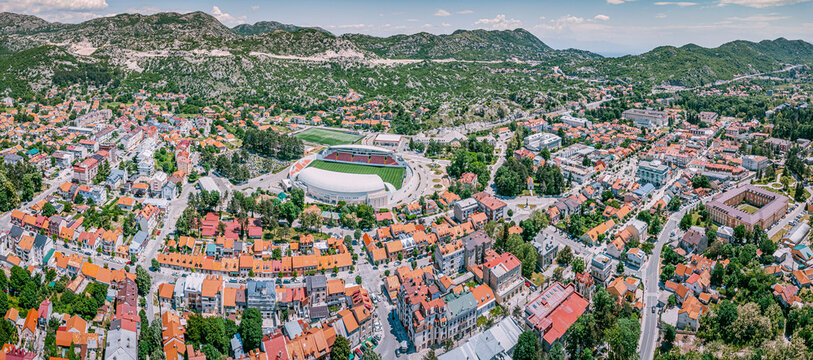 Cetinje city stadium and urban landscape with mountains, green hills, and residential buildings