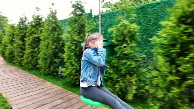 Happy Little Girl Riding a Backyard Zip Line, Excited Child Enjoying Outdoor Active Play in a Green Garden Setting, Joyful Childhood Activity