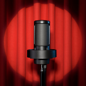 Microphone with spotlight on red stage curtain.